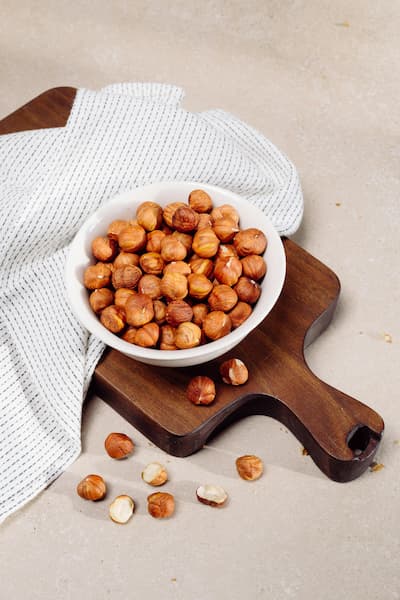 Hazelnuts in White Bowl on Cutting Board